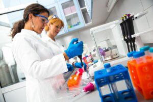 Two women in lab coats working in a laboratory.