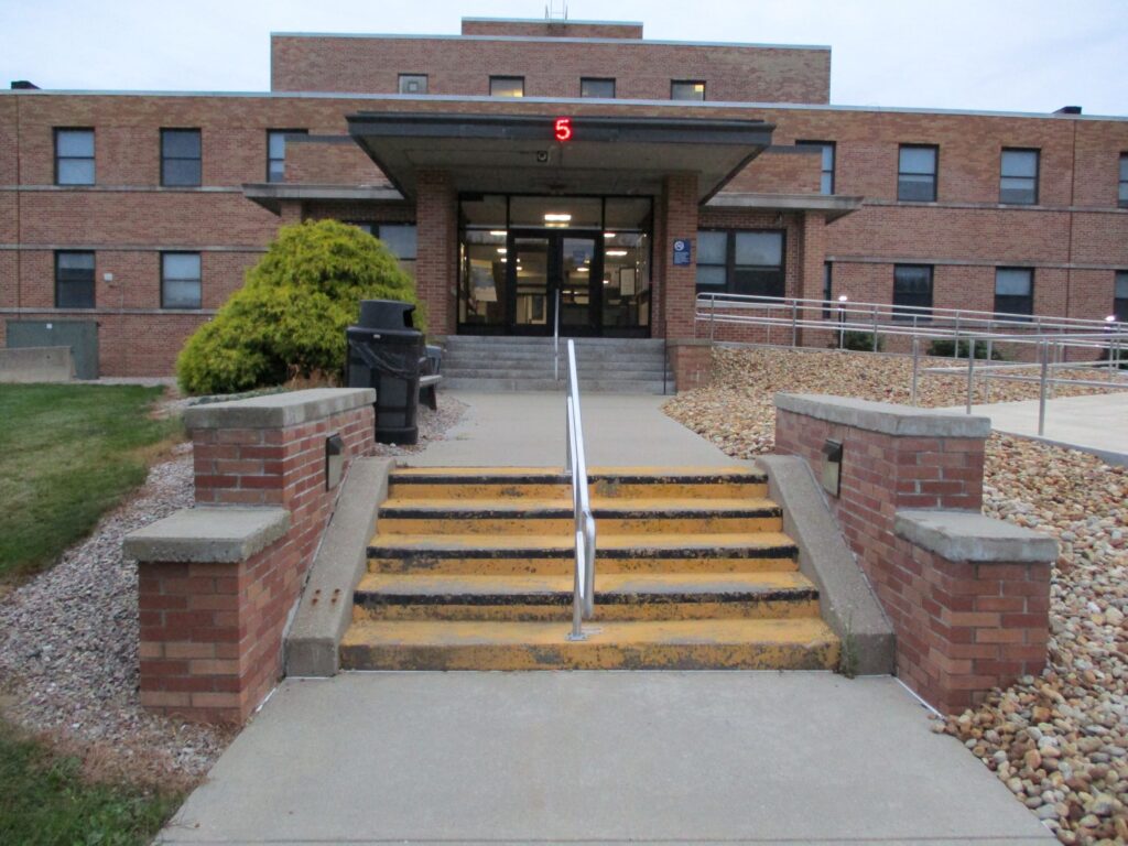 A building with yellow stairs and green bushes