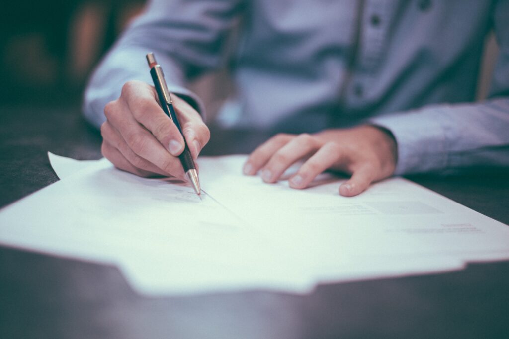 A person holding a pen and some documents