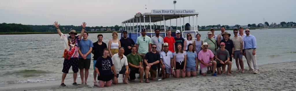 Group of people on a beach with a boat.